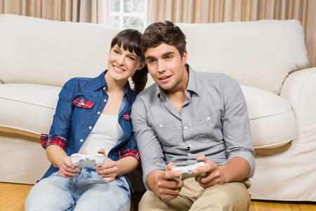 Couple playing video game in their living room