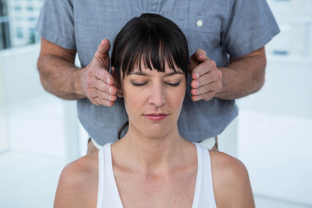 Pregnant woman receiving a head massage from masseur at the health spaの写真素材