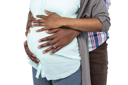 Man hugging pregnant woman from behind on white backgroundの写真素材