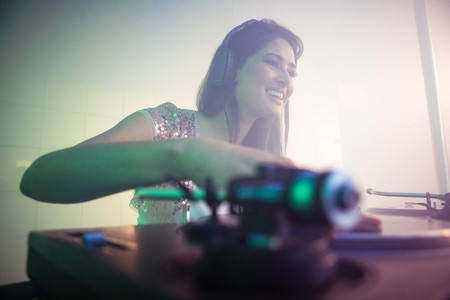 Pretty female DJ playing music at the nightclubの写真素材