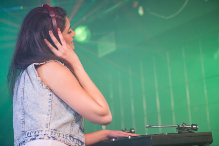 Pretty female DJ playing music at the nightclubの写真素材