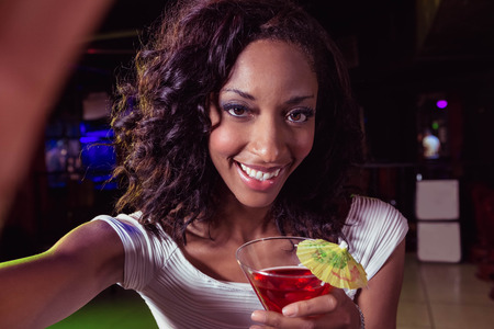 Portrait of young woman having a cocktail in barの写真素材