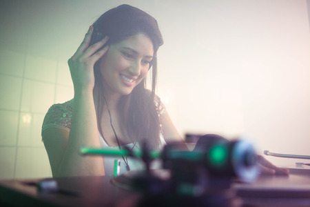 Pretty female DJ playing music at the nightclubの写真素材