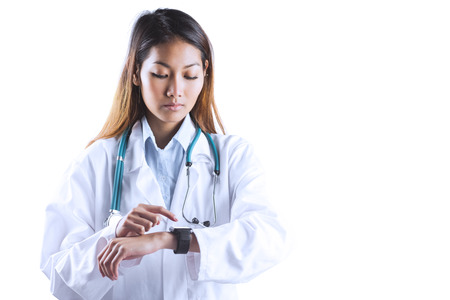 Asian doctor using her smart watch on white backgroundの写真素材