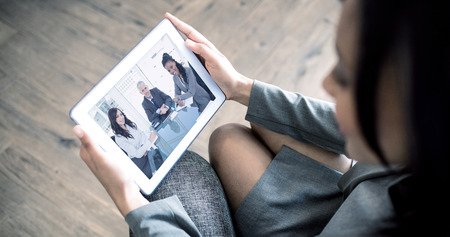 Businesswoman using tablet against smiling director sitting at the desk in front of the window...