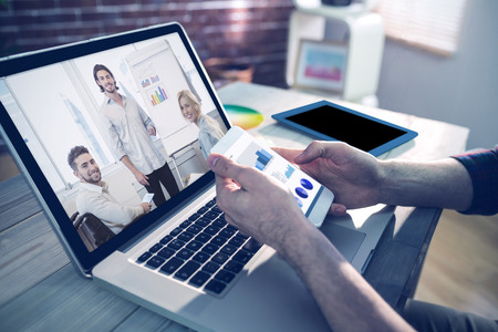 Business interface against cropped hand of graphic designer using smartphone and laptopの写真素材