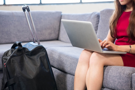 Close-up of business woman using laptop sitting on sofa in officeの写真素材