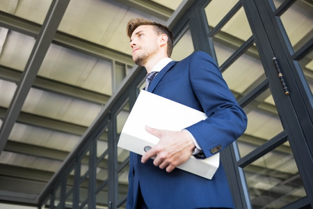 Businessman holding file with documents in officeの写真素材