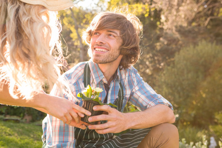 Smiling couple in the garden holding flowersの写真素材