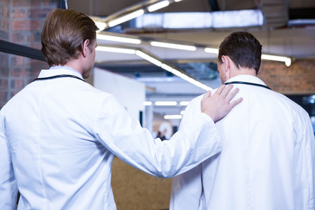 Rear view of doctors walking in hospital corridor