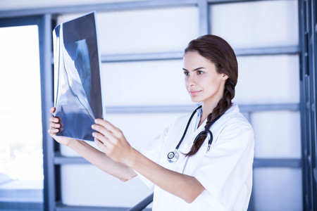 Female doctor examining a x report in hospitalの写真素材