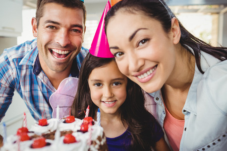 Close-up portrait of cheerful family celebrating birthday at homeの写真素材