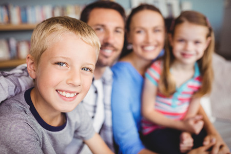 Close-up of happy boy with family on sofa at homeの写真素材