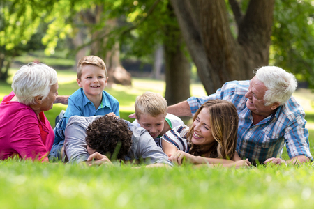 Smiling family lying in the grass in the garden