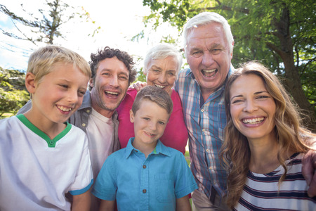Smiling family looking at camera in the gardenの写真素材