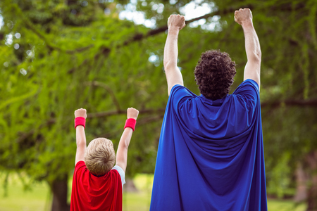Father and son dressed as superman in the gardenの写真素材