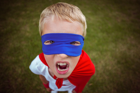 Little boy dressed as superhero in the gardenの写真素材