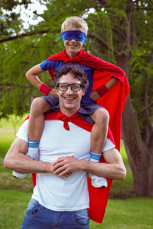 Father and son dressed as superhero in the gardenの写真素材