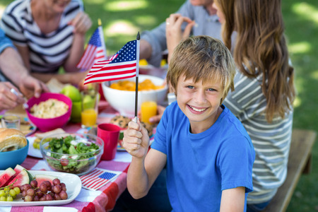 Family with American flag having a picnic in a parkの写真素材