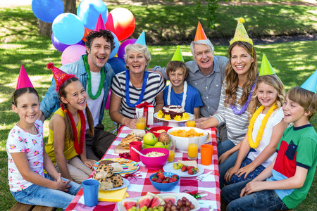 Happy family celebrating a birthday in the parkの写真素材