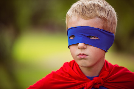 Little boy pretending to be superhero in parkの写真素材