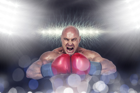 Aggressive boxer flexing muscles against spotlightの写真素材