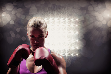 Portrait of woman fighter with gloves against spotlightの写真素材