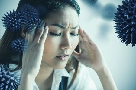 Nervous businesswoman holding her head against white background with vignetteの写真素材