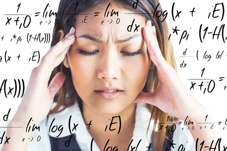 Nervous businesswoman holding her head against maths equation
