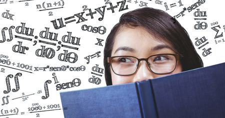 Pretty student hiding face behind a book against maths equation