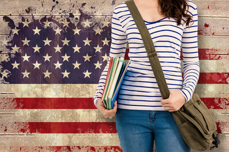 Mid section of man with should bag and files against usa flag in grunge effectの写真素材