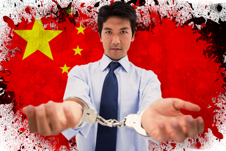 Businessman with handcuffs against chinaの写真素材