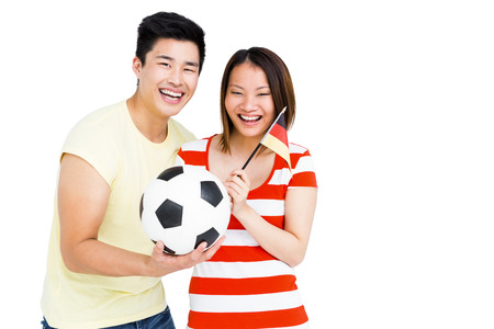 Excited couple holding football and flag on white backgroundの写真素材