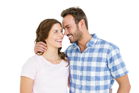 Happy young couple looking at each other and smiling on white backgroundの写真素材