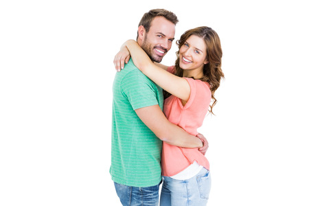 Portrait of happy young couple cuddling each other on white backgroundの写真素材