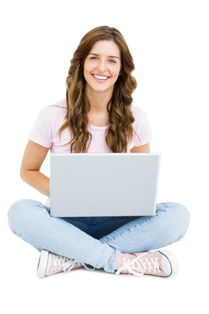 Portrait of young woman using laptop on white backgroundの写真素材