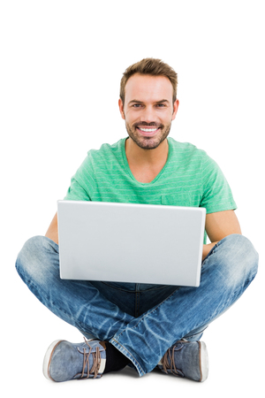 Portrait of young man using laptop on white backgroundの写真素材