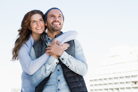 Happy couple embracing each other and smiling outdoorsの写真素材