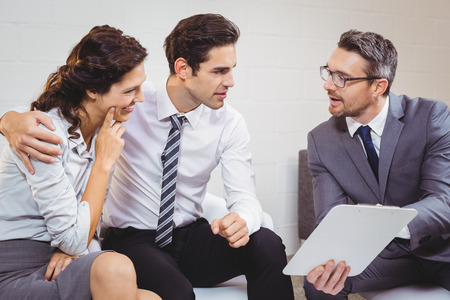 Business professional discussing with client while sitting at officeの写真素材