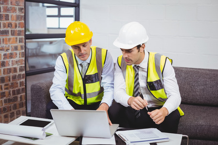Architects working on laptop while sitting in office