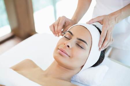 Close-up of beautiful woman receiving facial massage at spaの写真素材