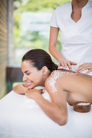 Close-up of young woman smiling while receiving spa treatmentの写真素材