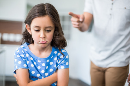 Midsection of father quarreling with daughter at homeの写真素材