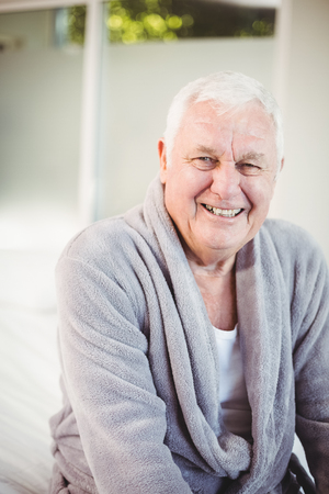 Portrait of smiling senior man in bedroom at homeの写真素材