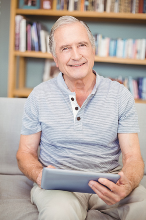 Close-up of senior man using digital tablet at home