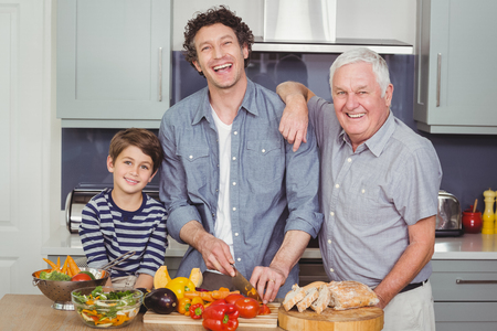 Portrait of happy family standing in kitchen at home