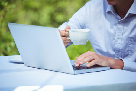 Businessman using laptop with coffee in a restaurantの写真素材