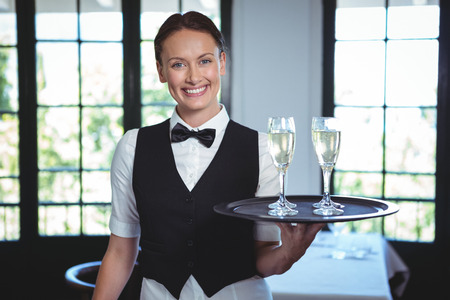 Waitress with a tray of flute of champagne in a restaurantの写真素材
