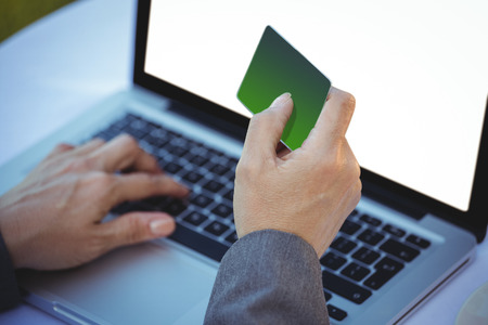 Businesswoman using her credit card to buy online in a restaurantの写真素材