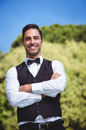 Handsome waiter smiling at camera outsideの写真素材